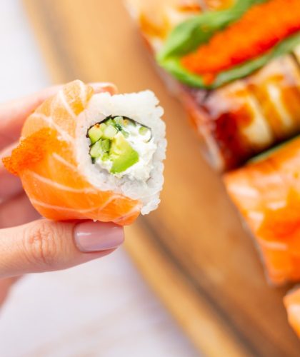 hand-holds-roll-with-salmon-cream-cheese